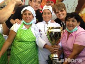  Triunfo. Doña Rosario Tabango y su equipo de trabajo levantan el trofeo que la certifica como la dueña del mejor hornado del mundo. 